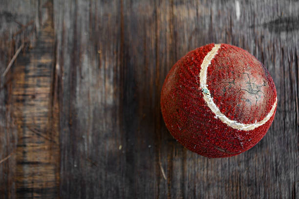 Old cricket ball on wooden surface