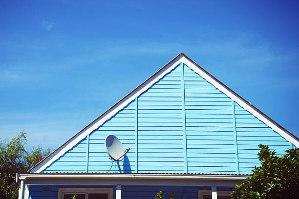 a satellite dish on the wall of wooden house, daytime shot