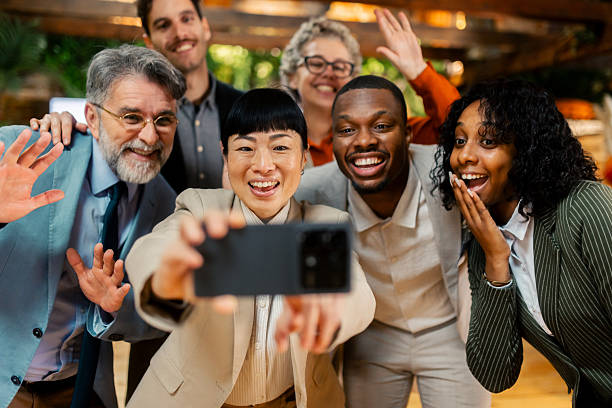 istock Diverse business team taking cheerful group selfie after succesful meeting 2256186113