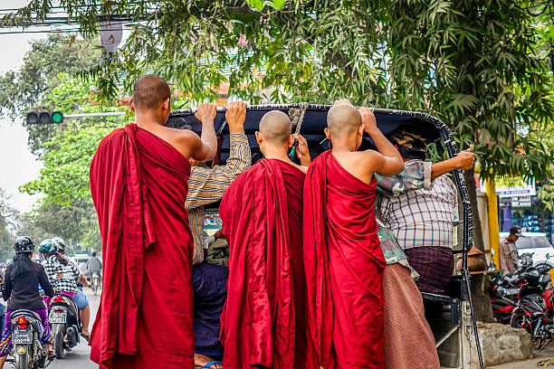 Mandalay, Myanmar - Feb 25, 2016. Buddhist novices stand on an old bus in Mandalay, Myanmar.