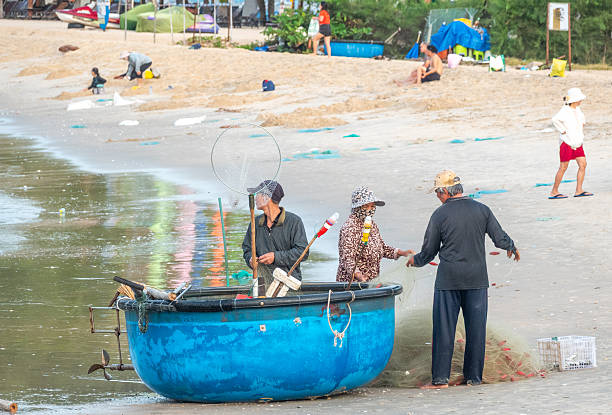 Fishermen with their basket boats at Mui Ne Beach in Binh Thuan Province, Vietnam