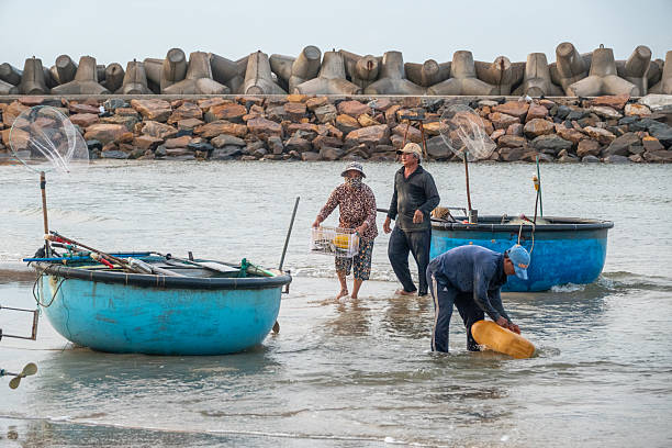 Fishermen with their basket boats at Mui Ne Beach in Binh Thuan Province, Vietnam