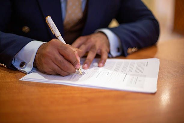 istock Businessman signing document, finalizing legal agreement contract 2256196498
