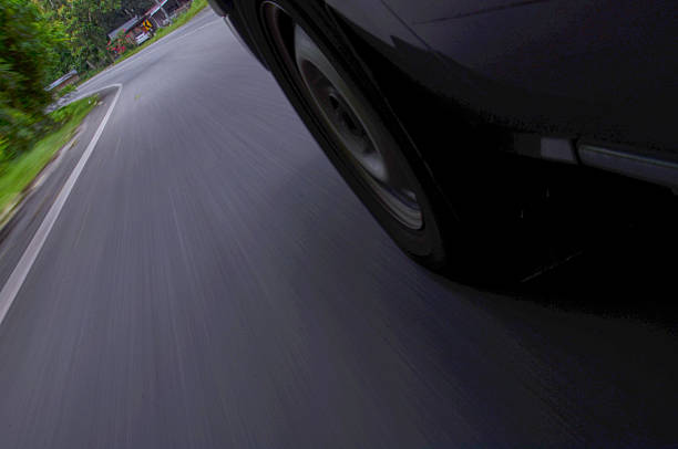 Front side view of black car in turn.