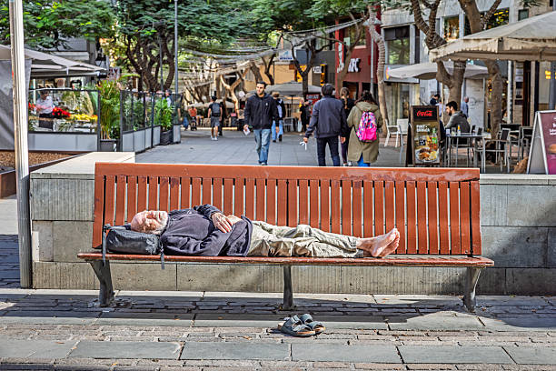 Santa Cruz, Tenerife, Spain, Europe - December 16th 2025: An elderly man is seen sleeping on a bench in the warm winter sun in Santa Cruz, the main city of Tenerife in the Canary Islands. The scene documents a quiet moment in a public urban space, reflecting the mild subtropical winter climate and everyday life in the city’s outdoor areas.