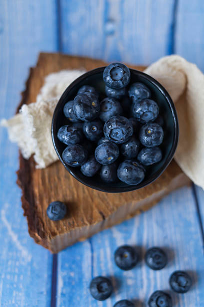 Blueberries lying on the table. Blue wooden background.