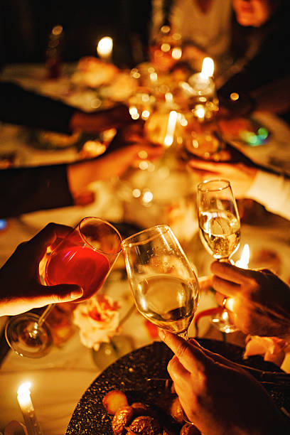 Friends gather around a beautifully set table, raising glasses in celebration. Flickering candles add warmth to a lively atmosphere filled with laughter and joy.