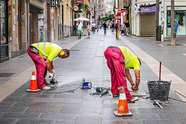 Santa Cruz, Tenerife, Spain, Europe - December 10th 2025: Two workers are seen repairing a pedestrian street in Santa Cruz, the main city of Tenerife in the Canary Islands.