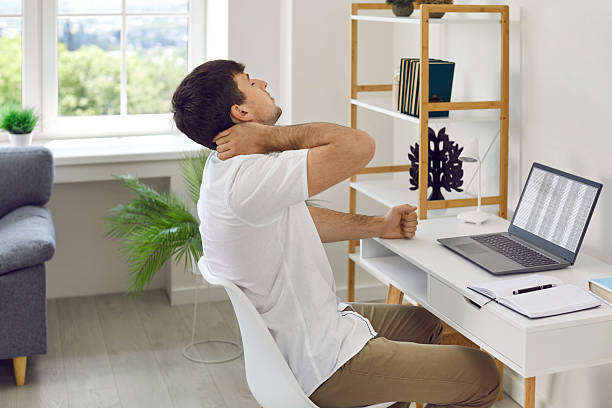 istock Young businessman who looks exhausted is massaging his neck while sitting at his workplace. 2256208644