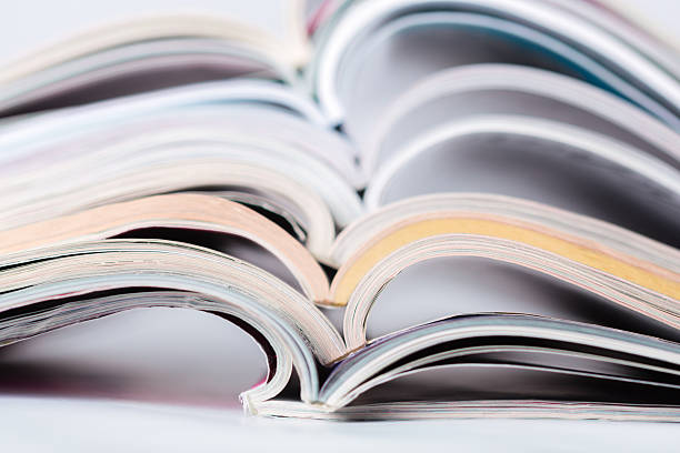 Several magazines are stacked and partially opened, displaying colorful pages inside.