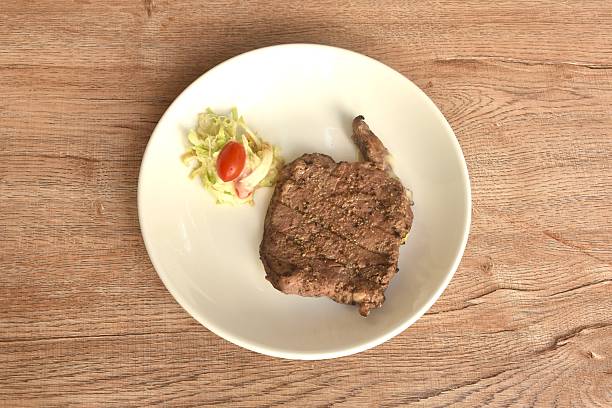 grilled pepper Ribeye beef steak and chop vegetable salad on plate