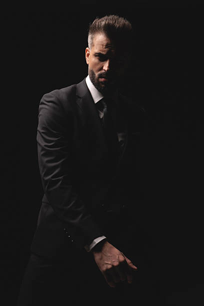 istock Mysterious man holding down his arm and posing 2256220566