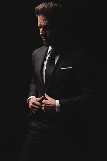 istock Elegant man closing his suit and looking away 2256220622