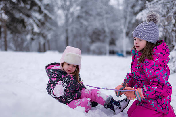 Two smiling children bundling up, playing outdoors in fresh snow, enjoying winter fun and friendship