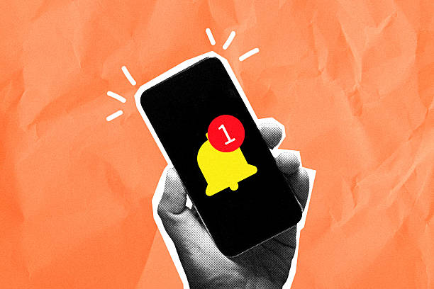 Hand holding mobile phone with yellow bell notification icon.New message alert,notification,digital reminder concept on orange textured background with copyspace.,Contemporary art collage style.