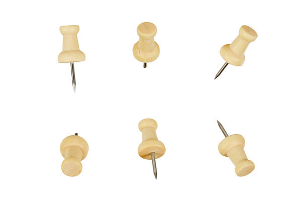 Many colourful push pins on wooden table