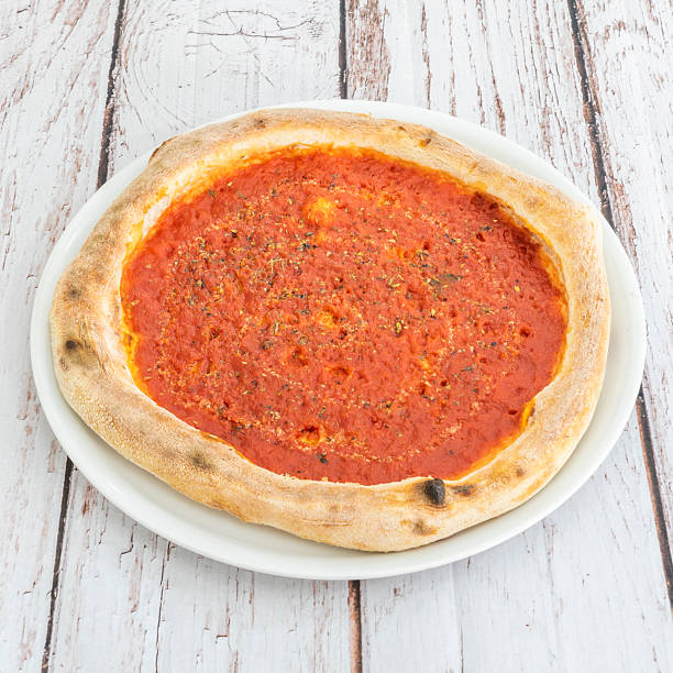 The classic Margherita pizza showcases its perfect simplicity with a base of tomato, fresh basil, and creamy burrata on a crispy crust