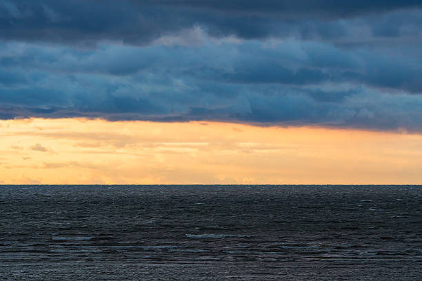Dramatic storm clouds approaching over the dark choppy waters of the Baltic Sea during a moody sunset in Northern Europe.High quality photo