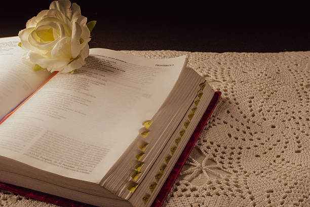 Bible opened and a white fabric rose representing faith and worship