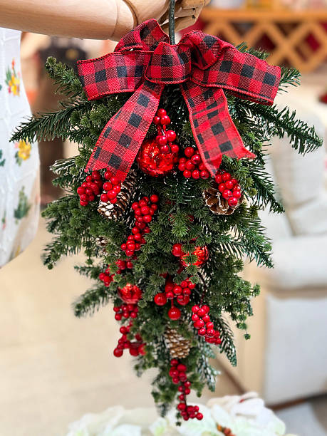 Image of christmas garland decorations, red and green tartan, berries, artificial spruce branches, pine cones, festive foliage, holiday decor, seasonal ornamentation