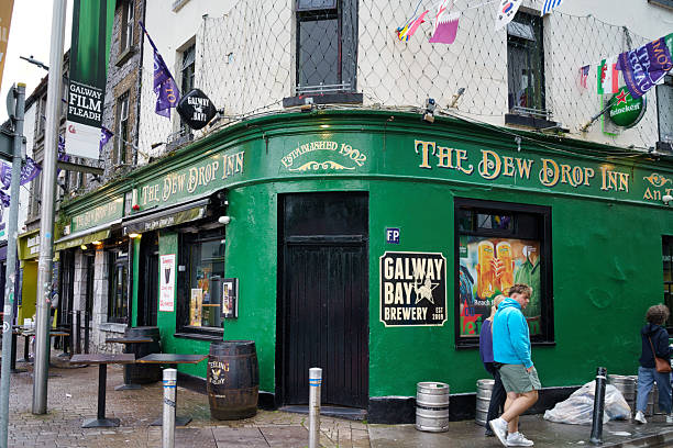 The Dew Drop Inn, a historic pub in Galway, Ireland, established in 1902, showcasing its green facade, signage, and surrounding streetscape. Ireland, 2025-08-08
