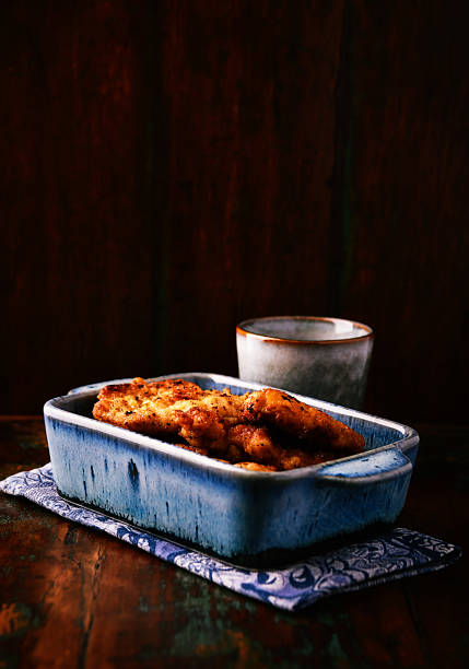 Fried chicken breast. Rustic wooden background. Soft focus.