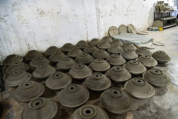 Densely packed display of white pottery on metal shelves in Fes, Morocco. Classic vase shapes, handmade craft, and warm light evoke traditional Moroccan artisan markets.