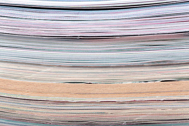 Papers are stacked in layers showing various colors and textures at a workspace.