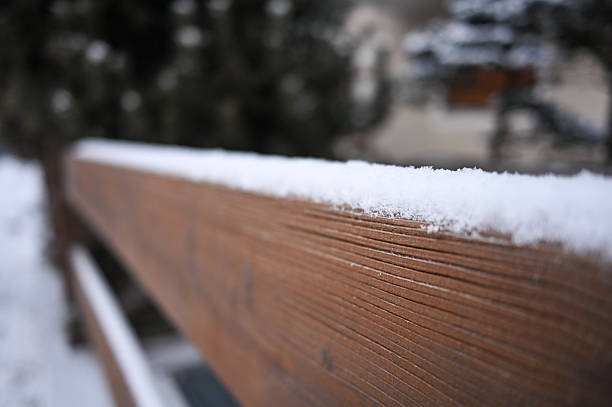 Wooden plank covered with fresh snow, creating a serene winter scene outdoors
