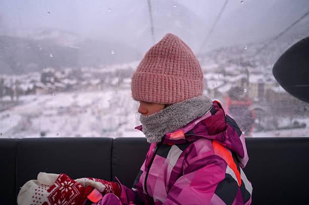 close-up portrait of a boy in a hat and snood scarf looking into the distance