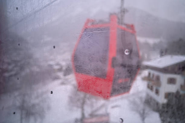 Red cable car moving up a snowy mountain at a winter ski resort