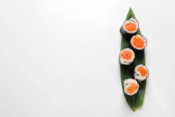 Delicious sushi rolls with salmon on white background, top view. Space for text