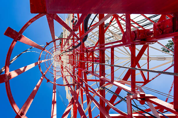 Wide angle view looking up technician access ladder and cage going up to top of 300 foot radio tower.