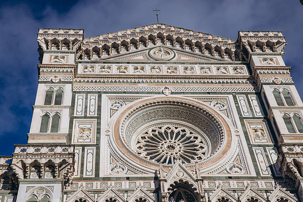 Florence Cathedral facade detailing renaissance architecture, colorful marble, and a large gothic rose window on a sunny day