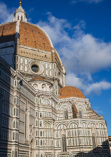 Florence Cathedral, also known as Duomo di Firenze. Brunelleschi's Dome and marble ornamentation against a blue sky