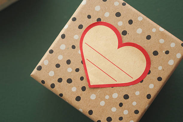 Happy Mother's Day gift tag with heart shaped gift box on blue background.