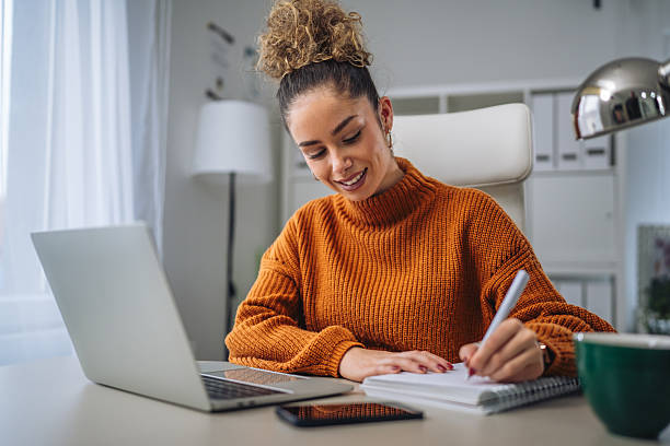 istock Woman working on laptop and writing in home office 2256280789