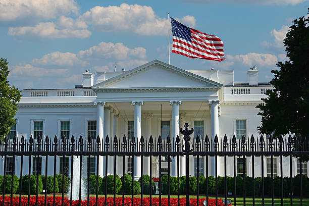 American Flags hang from the front of this traditional, brick homes in an All-American neighborhood.
