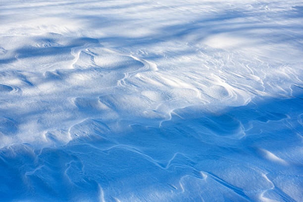 Christmas and winter holidays background from blue snow waves on snowy field