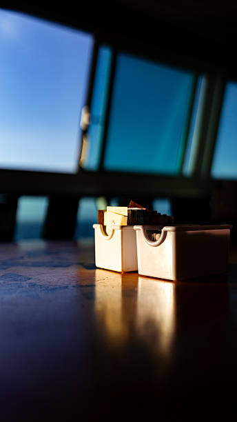 Small containers holding condiments on a table with sunlight highlighting
