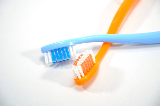 Bright pink toothbrush bristles on white background. Oral hygiene and teeth health care. Morning routine. Copy space.