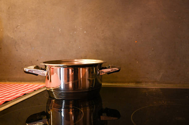 Steel cooking pot sitting on a modern kitchen induction stovetop