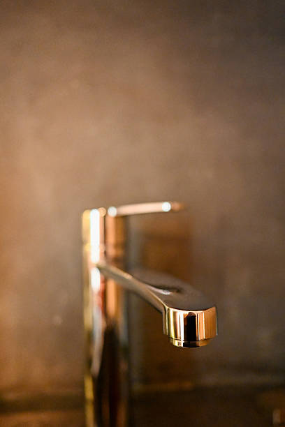 Polished modern copper faucet fixtures reflecting light in a contemporary interior design