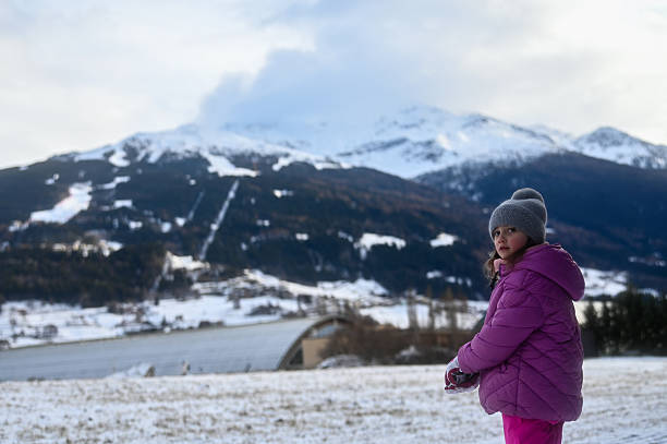 Young girl enjoying winter vacation in the snow-covered mountains
