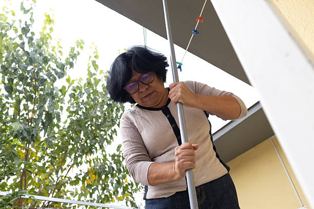 istock Woman wringing out a mop in her yard 2256301260