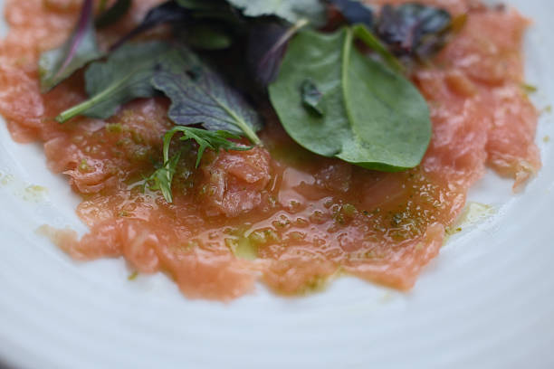 Gourmet salmon dish featuring smoked or raw cuts with toast or rice.
