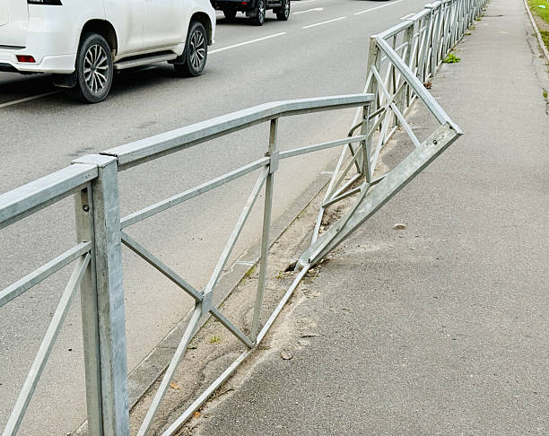 Bent Metal Crash Barrier Along Road Urban Roadside Scene Showing Deformed Guardrail, Dented Posts, Damaged Asphalt And Curb, Absent Vehicle, Aftermath Of High Speed Collision, Daytime