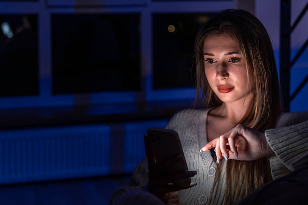 Eyes drawn to the screen with a highlighted hand gesture. An at home evening focused on messages with a calm Gen Z vibe.