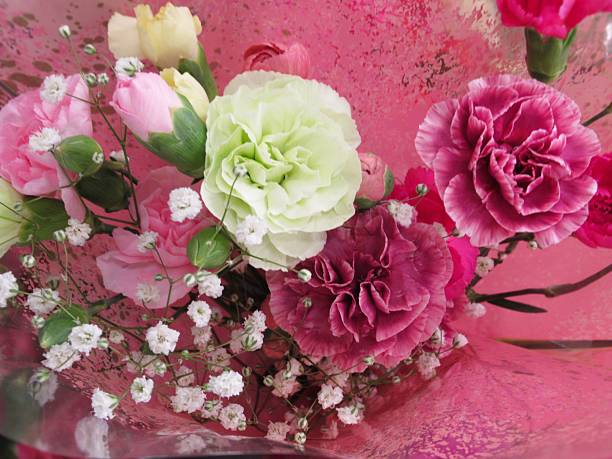 composition with gypsophila flowers and green chrysanthemums in a small gray vase located on a dark textured background