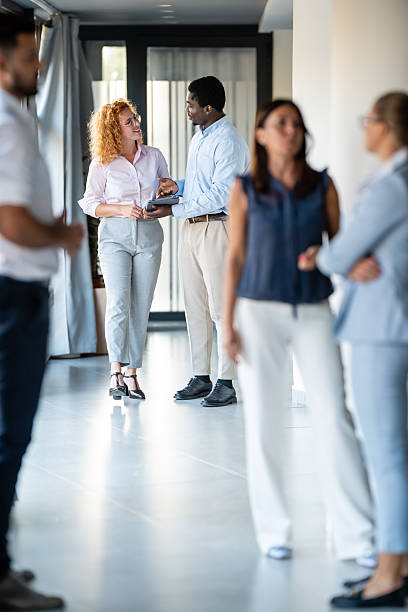 istock Business professionals networking and discussing ideas in modern office hallway 2256317225